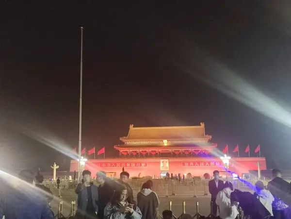 Tiananmen at night, searchlights sweeping the crowd
