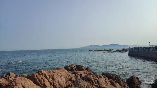 Rocks, and the hills across the water